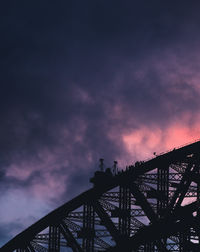 Low angle view of bridge against cloudy sky