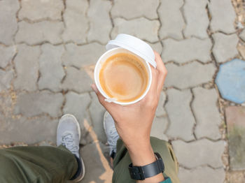 Low section of woman holding coffee on table