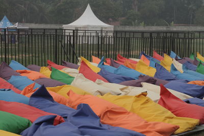 Multi colored umbrellas on field by lake against sky