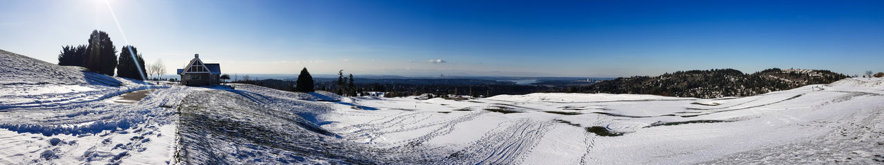 Snow covered landscape against blue sky