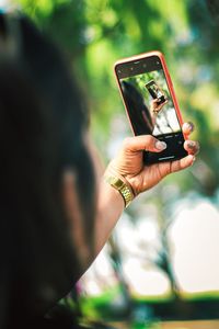 Hand holding smart phone outdoors