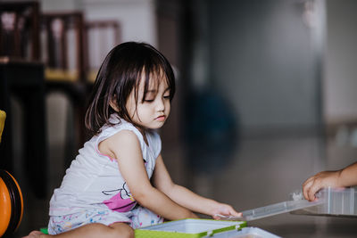 Cute girl with box sitting at home