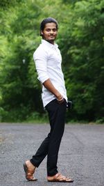 Portrait of young man standing on road