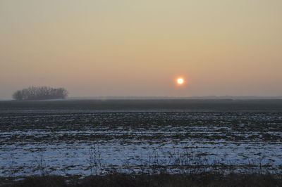Scenic view of field against sky during sunset
