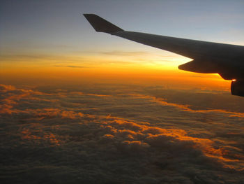 Scenic view of airplane wing against sky during sunset