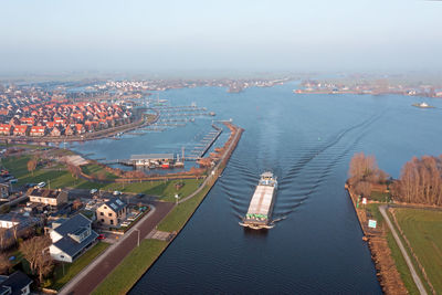 High angle view of city by sea against sky