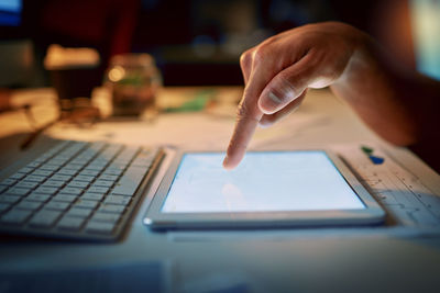 Cropped hand using laptop on table