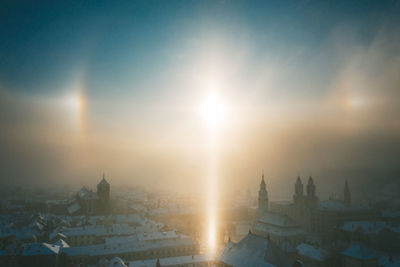 Sun shining over buildings in city