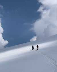 People skiing on snowcapped mountain against sky