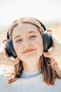 Young sunlit cute excited traveler tourist woman 20s wearing shirt summer casual clothes headphones