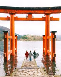 People standing on shore against sea