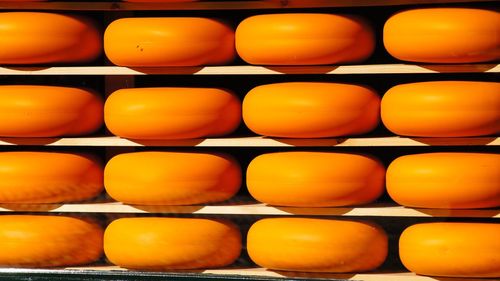 Rows of yellow gouda cheese on shelf