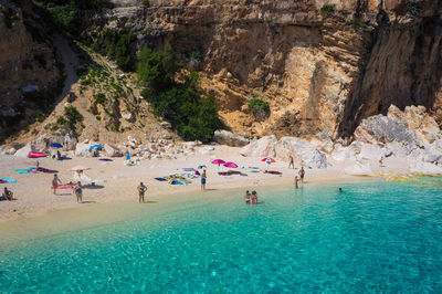 People swimming in pool by sea