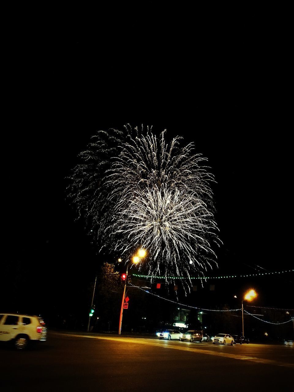 FIREWORK DISPLAY OVER STREET AT NIGHT