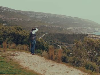 Side view of man standing against sky