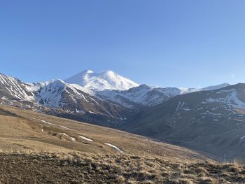 Scenic view of snowcapped mountains against clear blue sky