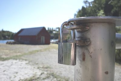 Close-up of metal structure on field against sky