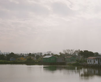 Scenic view of lake by building against sky