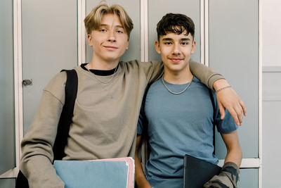 Teenage male friends standing in front of locker