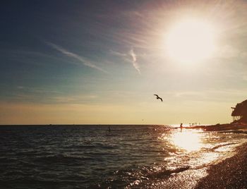 Sun shining through clouds over sea