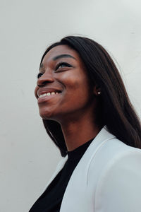 Close-up of smiling young woman against white background