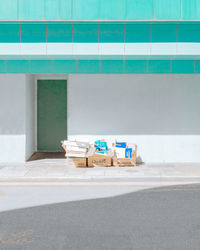 Stack of garbage bin on street against wall