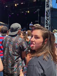 Portrait of woman sticking out tongue during concert