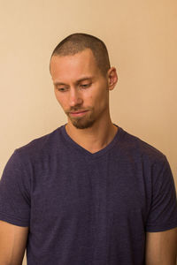 Portrait of young man standing against wall