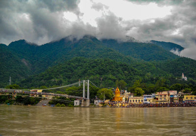 Scenic view of river by mountains against sky