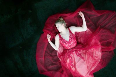 High angle view of woman lying on red carpet