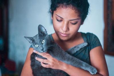 Close-up portrait of young woman holding cat