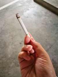 Close-up of hand holding cigarette