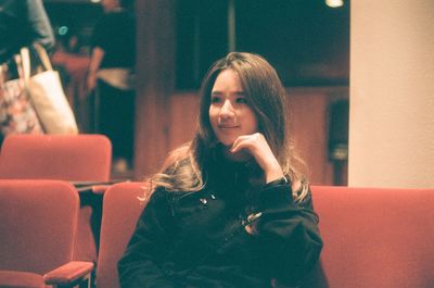 Portrait of smiling young woman sitting outdoors