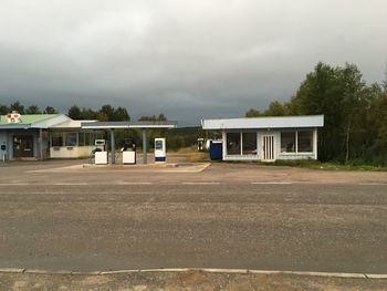 Empty road by building against sky
