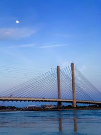 Suspension bridge over sea against sky