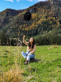 Full length of young woman sitting on field