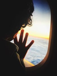 Man looking at sea seen through airplane window