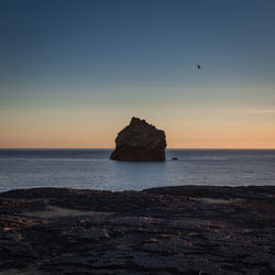 Scenic view of sea against clear sky at sunset