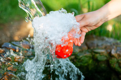 Close-up of hand holding balloon in water