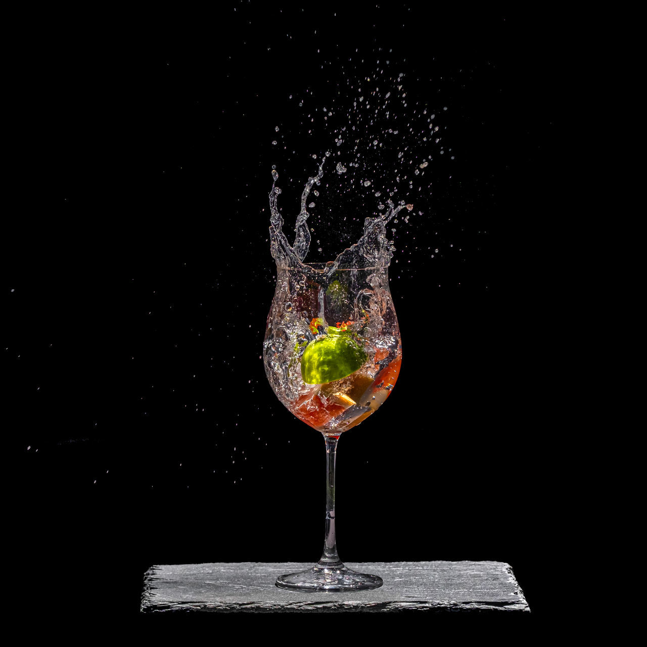 CLOSE-UP OF WINE GLASS AGAINST BLACK BACKGROUND