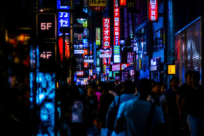 Crowd at illuminated street market during night