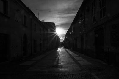 Empty road amidst buildings in city