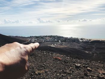 Midsection of person on beach against sky