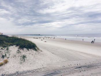 Scenic view of beach against cloudy sky