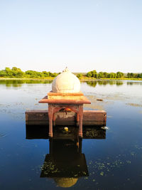 Built structure in lake against clear sky