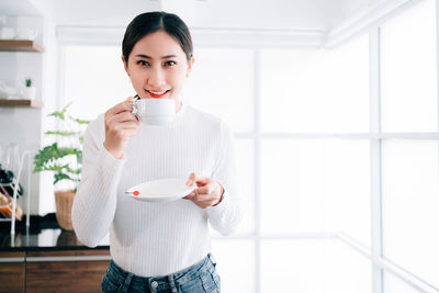 Portrait of smiling woman holding coffee cup