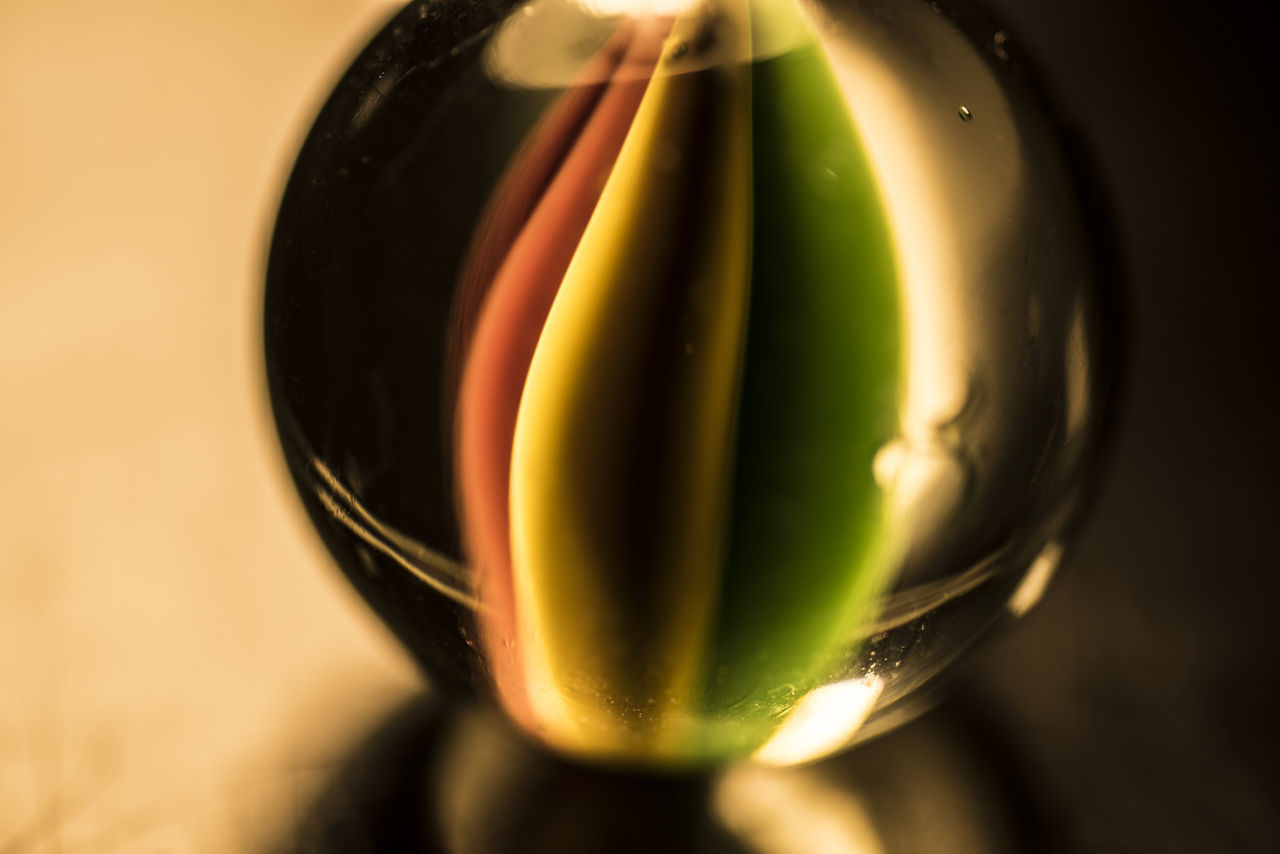 CLOSE-UP OF MULTI COLORED BALL IN GLASS CONTAINER