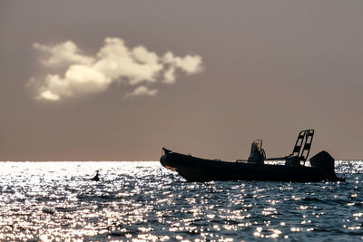 Silhouette ship sailing in sea against sky during sunset