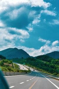 Empty road along landscape against sky