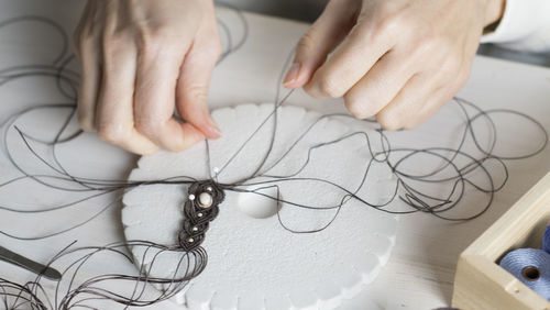 High angle view of woman working with thread on table